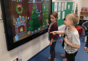 dzieci ubierają choinkę na tablecie interaktywnym